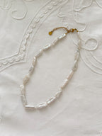 Biwa pearl necklace flat lay with organic freshwater pearl details