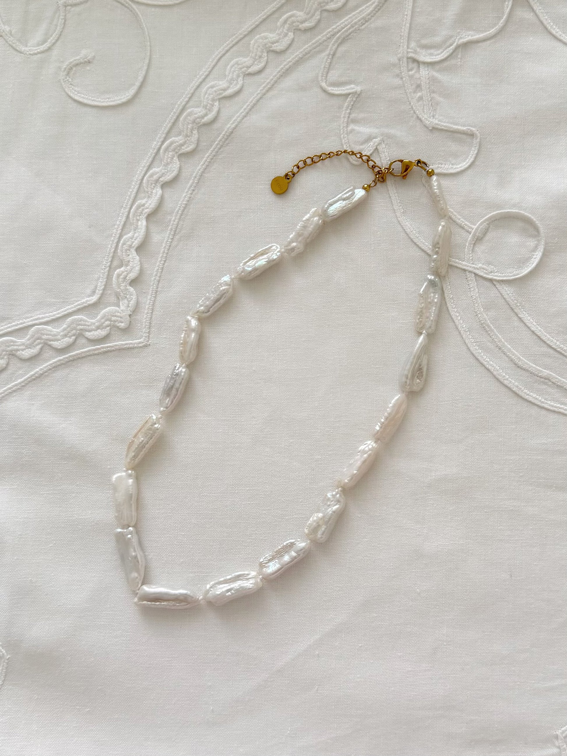 Biwa pearl necklace flat lay with organic freshwater pearl details