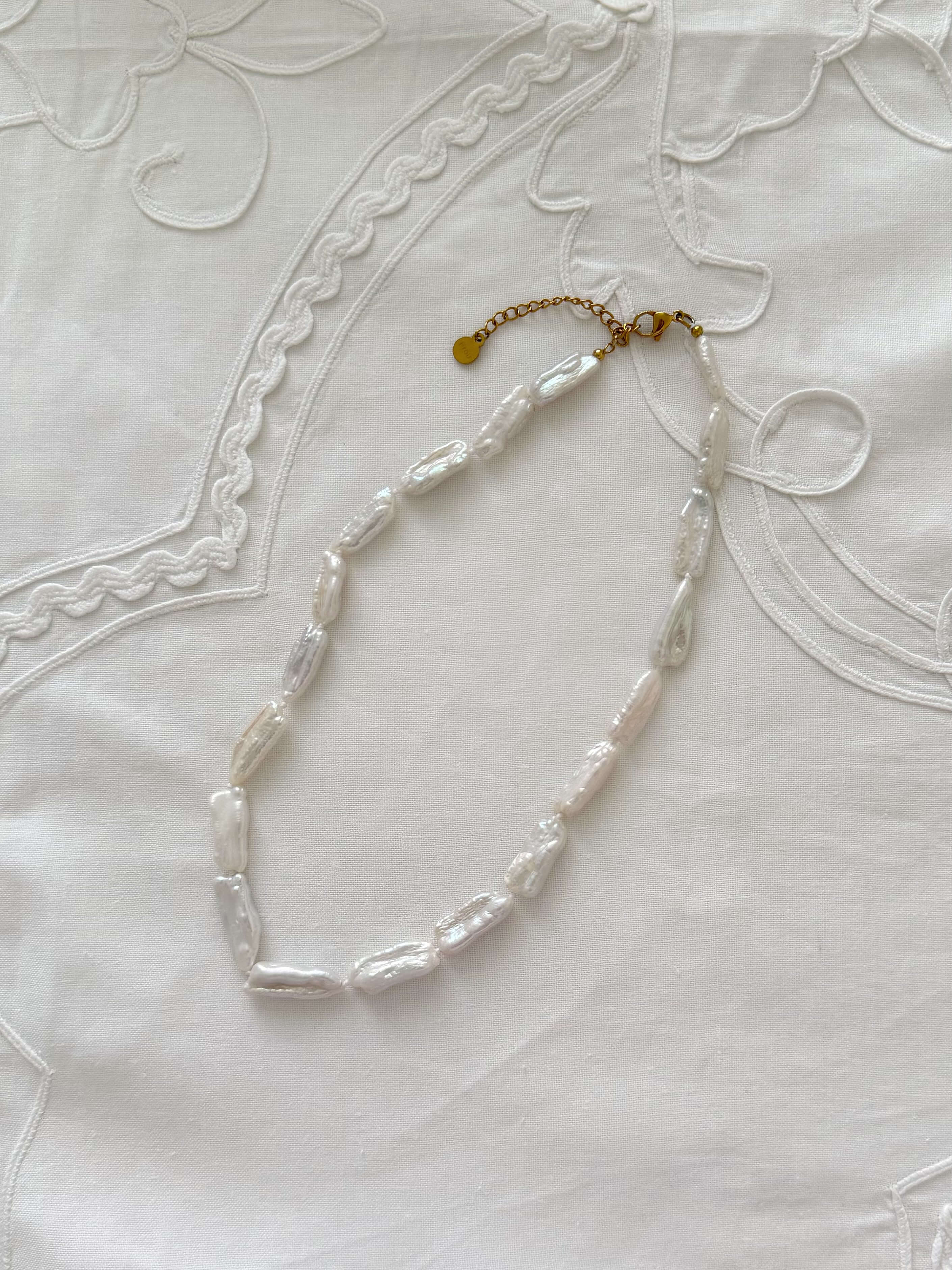 Biwa pearl necklace flat lay with organic freshwater pearl details
