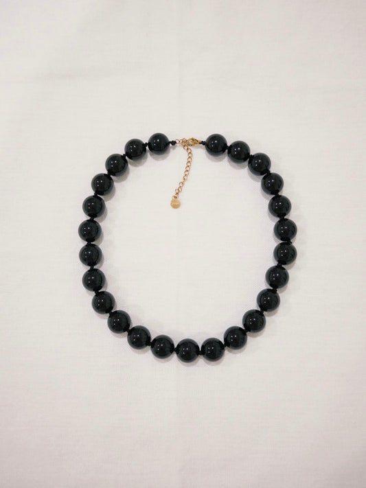 Black agate bead necklace flat lay with bold natural stone details