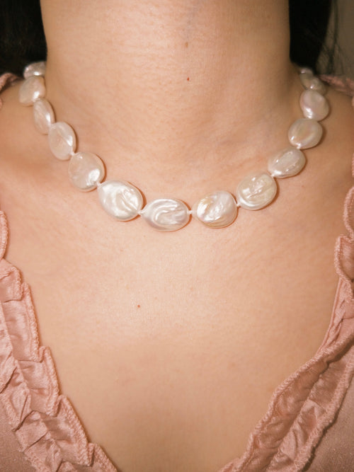 Button pearl necklace worn on neck with bold everyday pearl styling