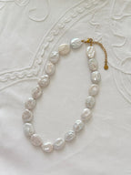 Button pearl necklace flat lay with oversized freshwater pearl details