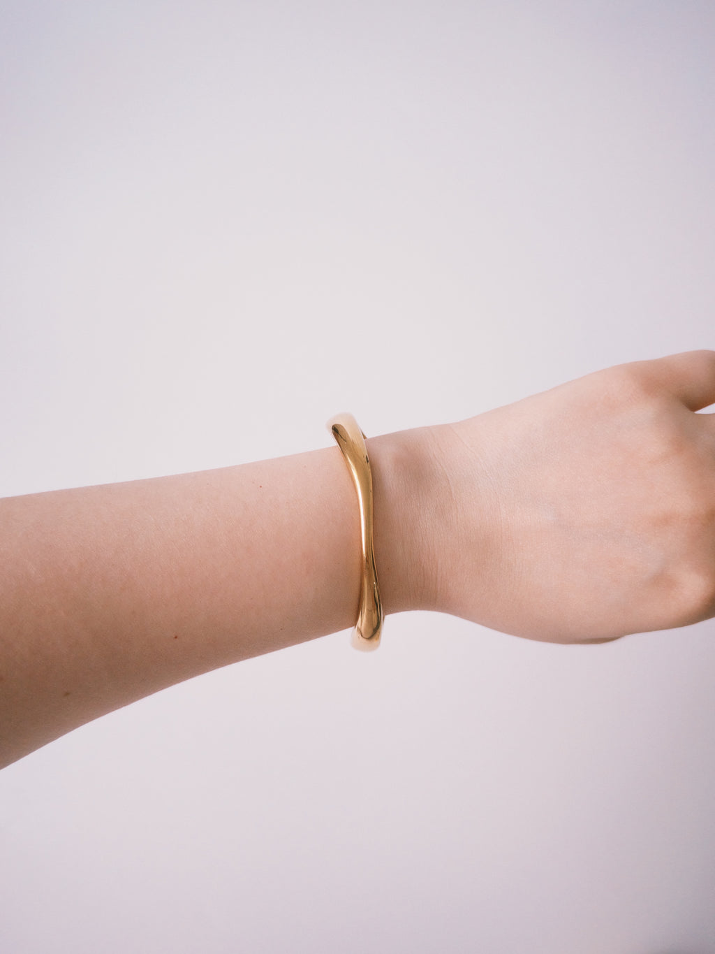 Gold minimalist cuff bracelet worn on wrist