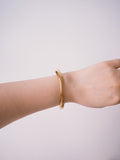 Gold minimalist cuff bracelet worn on wrist