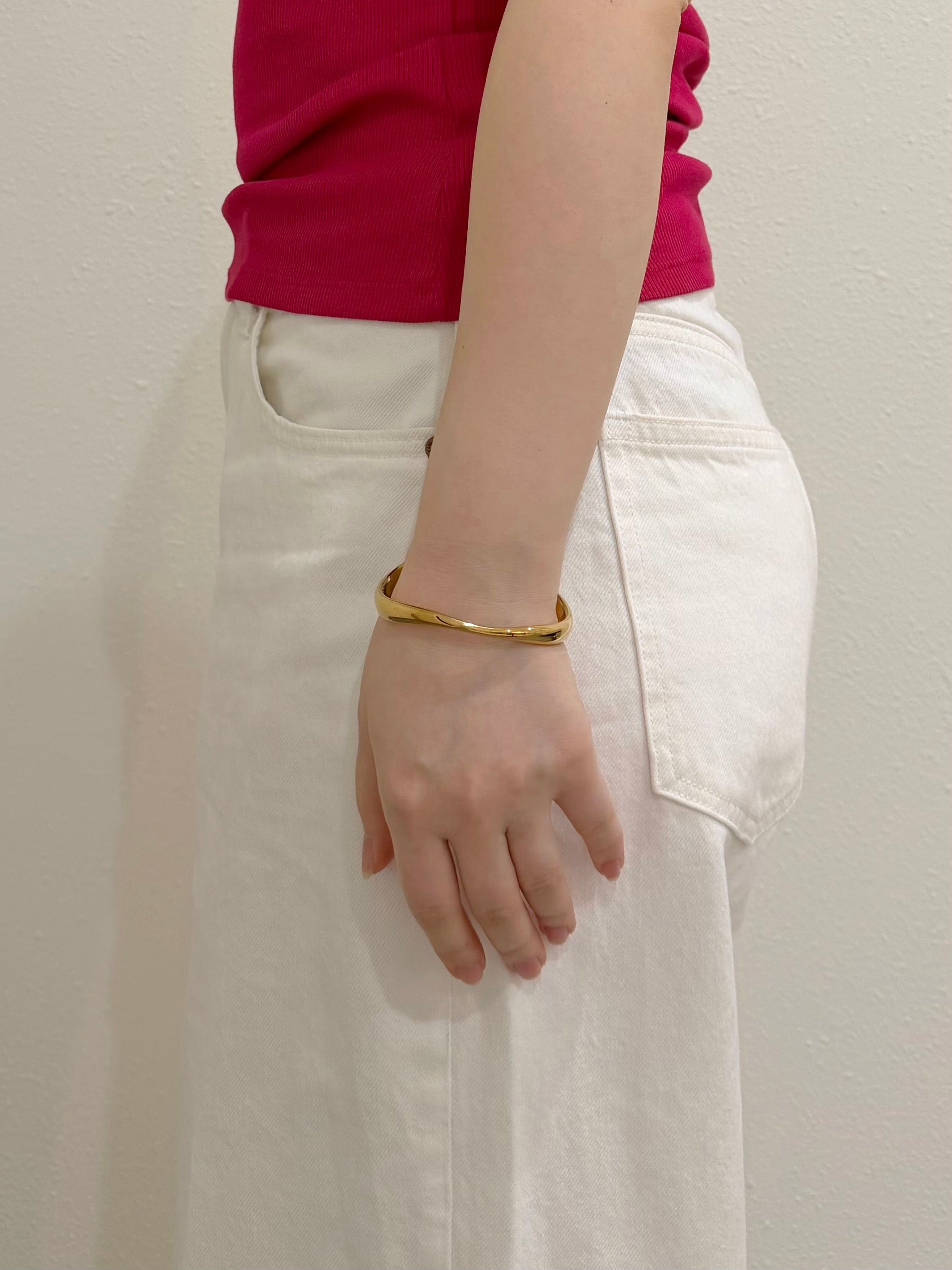 Gold open cuff bracelet worn with relaxed everyday outfit