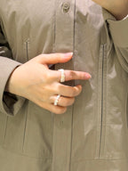 Layered pearl rings styled casually on hand with relaxed everyday jewelry