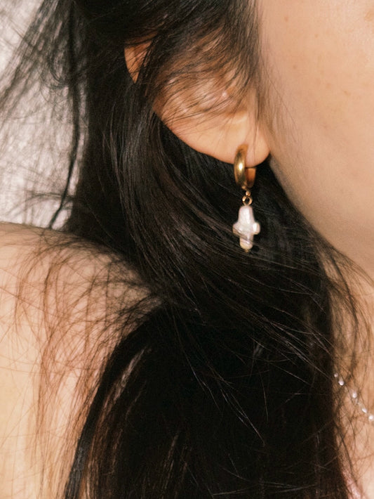 Delicate pearl drop earrings styled softly with relaxed everyday jewelry