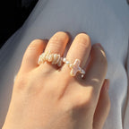 Pearl cross ring worn on hand in soft natural light