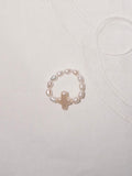 Pearl cross ring flat lay with minimalist everyday styling
