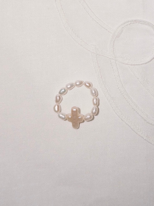Pearl cross ring flat lay with minimalist everyday styling