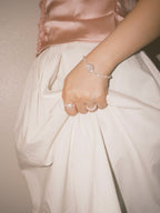 Statement pearl bracelet paired with soft neutral textures in warm natural lighting