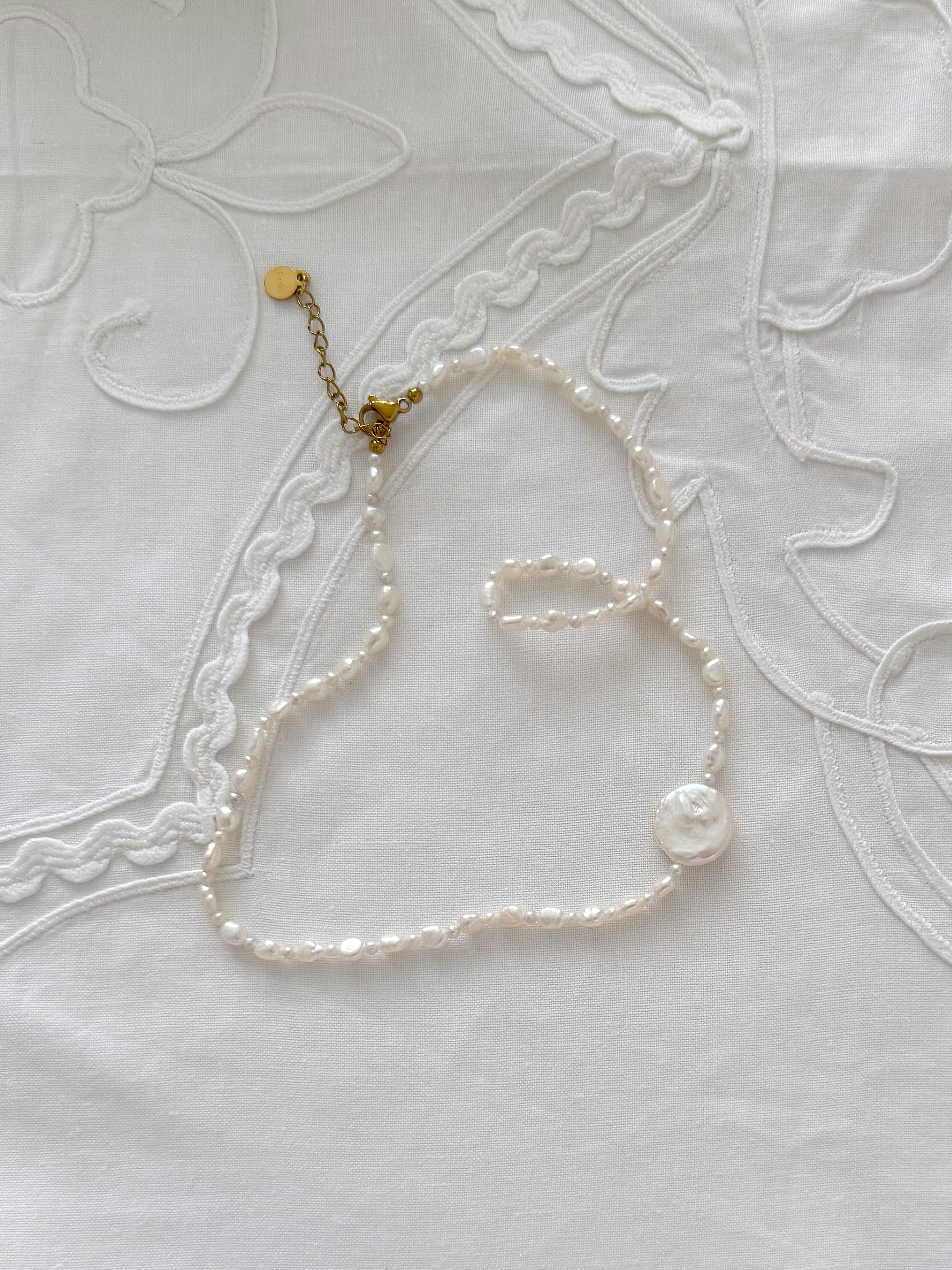 Freshwater pearl necklace detail with minimal styling and soft natural tones