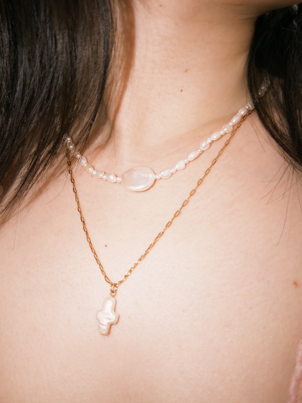 Layered pearl necklace styled with gold chains for relaxed everyday wear
