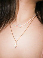 Layered pearl necklace styled with gold chains for relaxed everyday wear