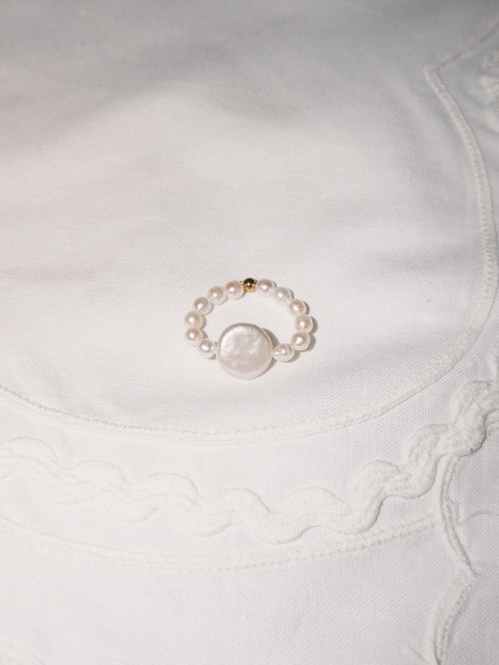 Freshwater pearl ring displayed on soft neutral fabric with minimal styling