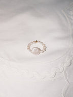 Freshwater pearl ring displayed on soft neutral fabric with minimal styling