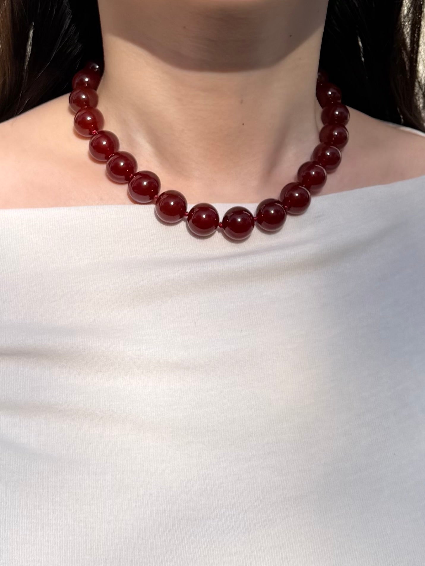 Red agate necklace worn on neck with bold everyday styling