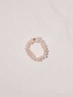 Pearl cross ring flat lay with soft neutral styling