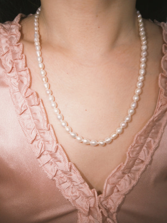 Minimal freshwater pearl necklace styled softly for everyday wear