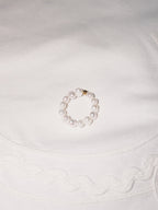 Minimal pearl ring displayed on soft neutral fabric