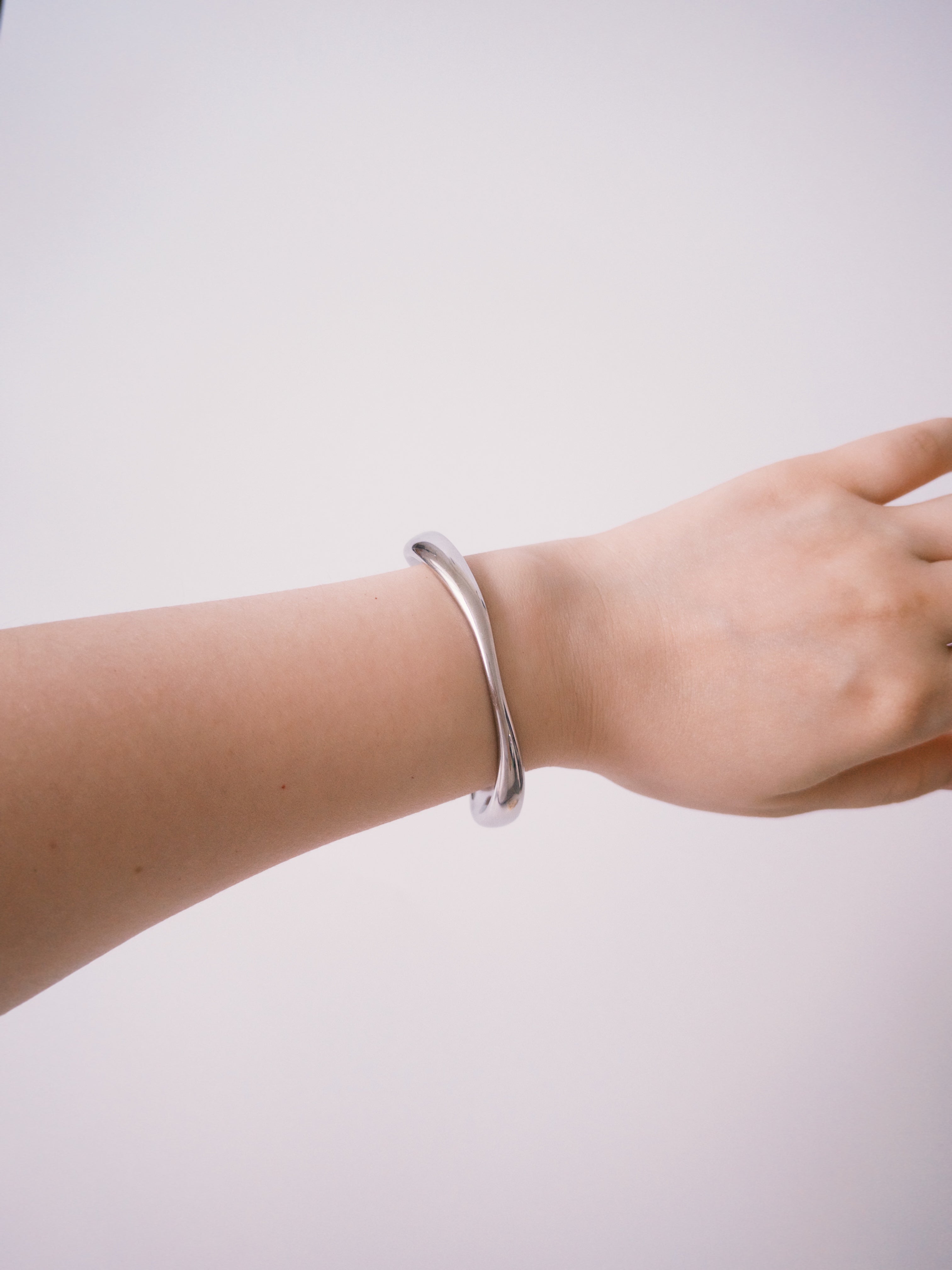 Silver minimalist cuff bracelet worn on wrist
