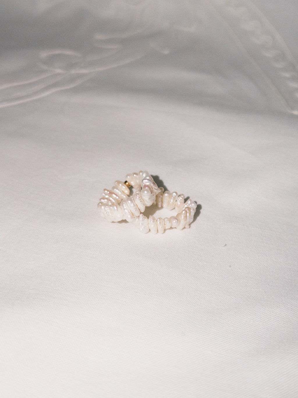 Stacked pearl rings arranged casually in soft natural light